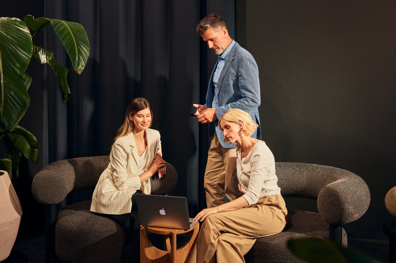 Drei Nutzer schauen auf ein Notebook